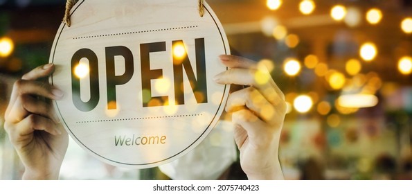 wide banner. waitress staff woman wearing protection face mask turning open sign board on glass door in cafe coffee shop, hotel service, cafe restaurant, retail store, small business owner concept - Powered by Shutterstock