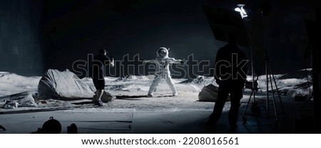 WIDE Behind the scenes, cinematographer shooting viral video for social account on a large Moon landing set. Virtual production with LED screens