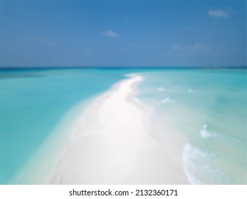 The wide blue sea and white sand like the road in the middle are photographed during the day in a blurry view