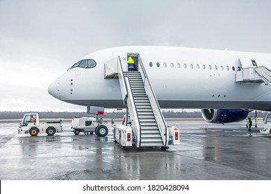 Wide body aircraft with ladder stairs to the airport parking