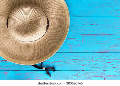 Wide Brimmed Straw Gardening Hat On An Old Weathered Colorful Blue Picnic Table With Copy Space In An Overhead View