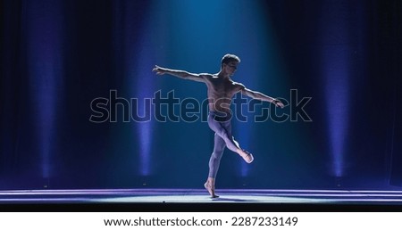 Wide Cinematic Shot of Athletic Man Dancing and Rehearsing Pirouettes on Classic Theatre Stage with Dramatic Lighting. Graceful Classical Ballet Male Dancer Performing his Choreography Professionally