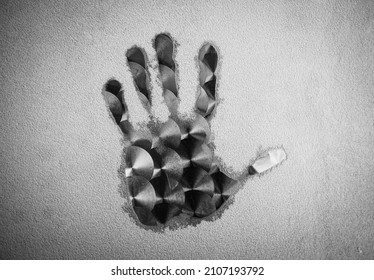 Wide Close Shot Of Hand Print On Metal Circular Brushed Stainless Steel Table Top Covered In Ice Crystals