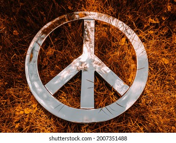 Wide Close Shot Of Peace Sign For Nuclear Disarmament Set Against A Fiery Orange Grass Background 