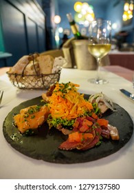 Wide Closeup Of A Fancy Entree Of Smoked Salmon And Foie Gras Served On A Slate Plate At A Gourmet Restaurant With White Wine. Vertical Orientation. Colmar, France. Travel And Gourmet Dining.