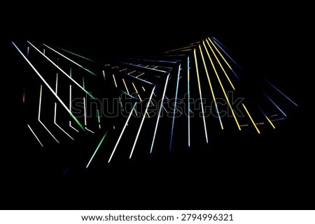 Wide composition of multicolored glowing lines and angular shapes spreading across a black background.