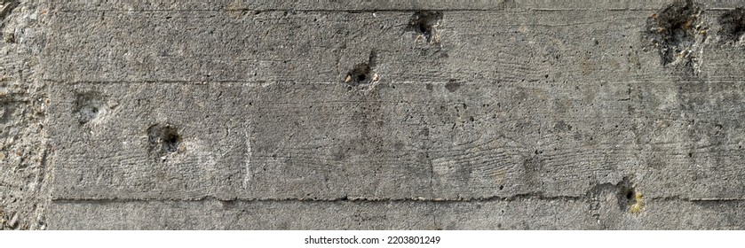 Wide Concrete Wall With Bullet Holes Background. Bullet Holes On A Gray Concrete Wall Of A Second World War Bunker In Normandy