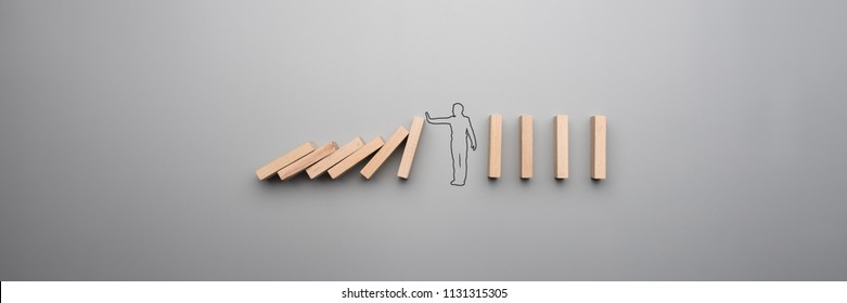 Wide cropped image of the outline of a businessman stopping the domino effect on gray background.