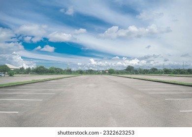 Wide empty asphalt parking lot background. with many cars parked background. outdoor empty space parking lot with trees and cloudy sky. outside parking lot in a park