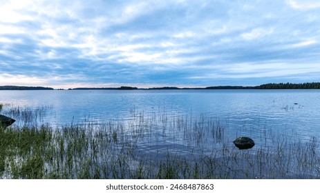 A wide expanse of water containing a solitary rock in the center - Powered by Shutterstock