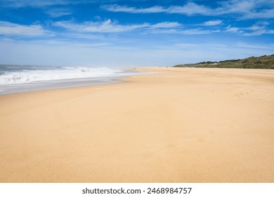 The wide golden sands of North Beach (Praia do Norte) near the Nazare lighthouse bluff where the famous surfing waves of Nazare, Portugal break. - Powered by Shutterstock