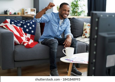 Wide Image Of Black Man Cheering In Front Of TV