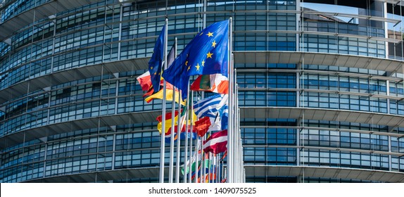 Wide image flags of all member states of the European Union waving in calm wind in front of the Parliament headquarter on the day of 2019 European Parliament election.