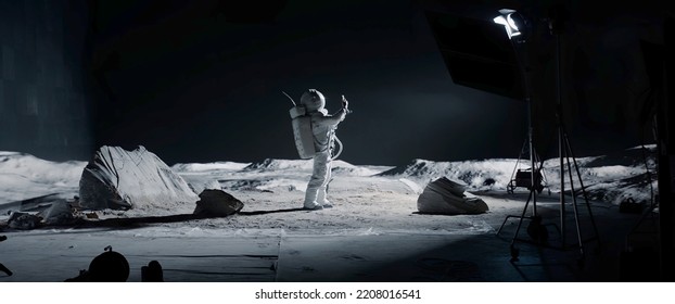 WIDE Male actor in astronaut suit making selfie on a Moon Lunar movie shooting set
