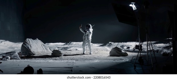 WIDE Male actor in astronaut suit making selfie on a Moon Lunar movie shooting set - Powered by Shutterstock