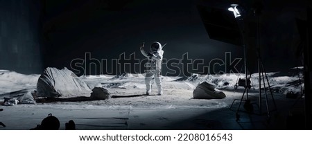 WIDE Male actor in astronaut suit making selfie on a Moon Lunar movie shooting set