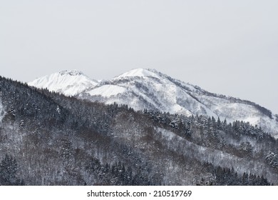 Wide mountain view in Japanese Alps with snow-covered peaks and evergreen trees