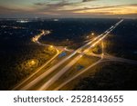 Wide multilane highway crossroads in Florida, USA with fast driving cars at sunset. Above view of American transportation infrastructure