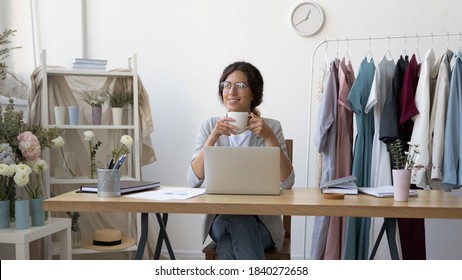 Wide narrow image of happy young female fashion designer drink coffee look in distance dreaming thinking. Happy Caucasian creative businesswoman work on laptop enjoy morning in modern home office. - Powered by Shutterstock