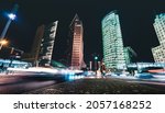 Wide nightscape of Potsdamer Platz with unrecognizable people and blurred traffic jam after blue hour - Low point of view composition with blurry car lights tracks in Berlin capital city of Germany