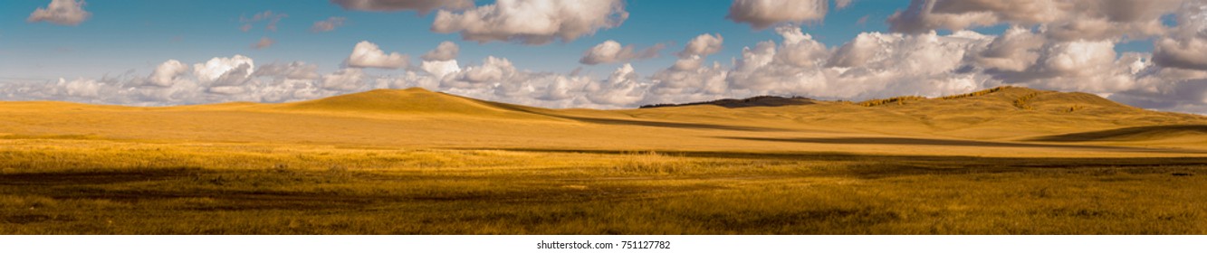 Wide panorama of beautiful autumn field. Majestic open space under dramatic clouds. Kazakh steppe.
