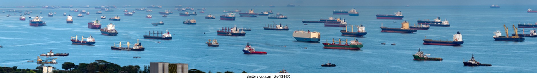 Wide panorama image of Container Ships and tankers anchored at the Singapore strait.