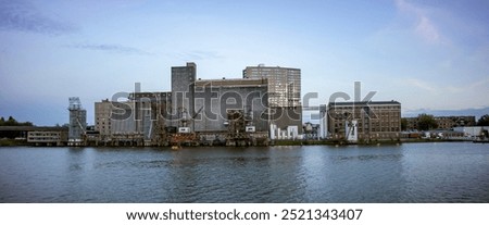 Wide panorama of old industrial processing factory and silo building on the shore of the Maas river in the Dutch harbour infrastructure port city of Rotterdam