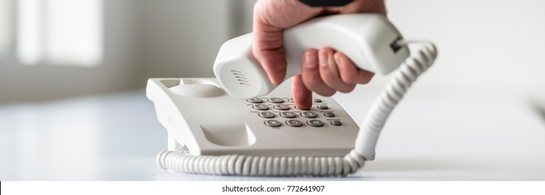 Wide Panorama View Of A Male Hand Dialing A Telephone Number In Order To Make A Phone Call.