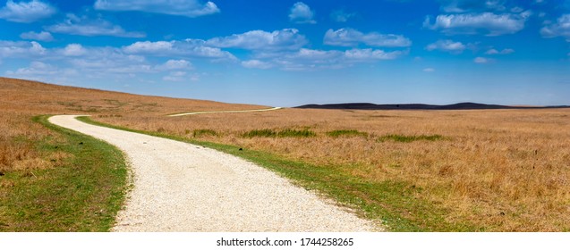 Wide Panoramic View Of The Kansas Tallgrass Prairie Preserve With Its Rolling Hills And Long Winding Road.