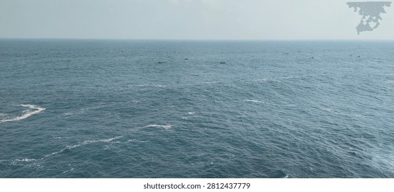 Wide panoramic view the open ocean with gentle waves and a distant horizon under a clear daytime sky. Peaceful seascape showcasing the beauty of tropical waters and a tranquil coastal environment in Indonesia.