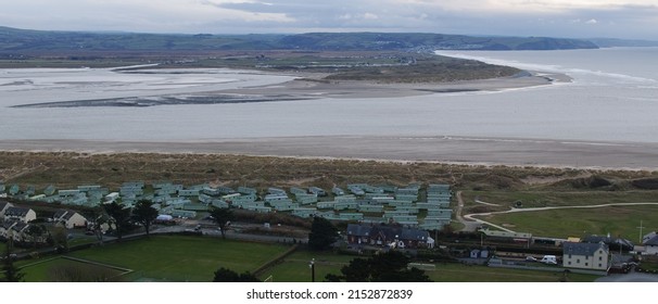 Wide panoramic vista of mouth of Dovey estuary, Ynyslas and Aberdovey, Wales. Coastal river mouth at seaside with beaches and sea, tourist caravan holiday park foreground with mountains background