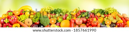 Wide pattern of ripe fruits and vegetables on green natural background.