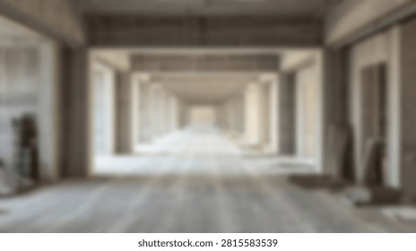 Wide perspective view of a long empty hallway inside a modern concrete building during the construction phase with natural light.