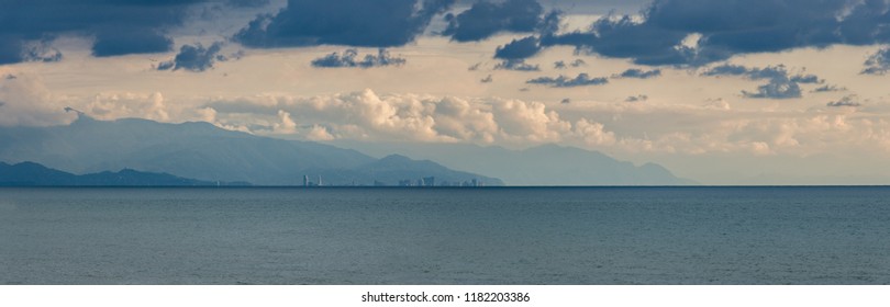 The Wide Photo Of A Buildings, Town Named Batumi In Georgia, On The Horizon Of The Sea, Behind Mountains And Above The Clouds All In Light And Dark Blue, Photo For Living Room