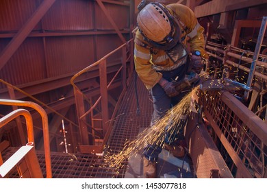 Wide shoot construction worker boiler  wearing personnel safety protection PPE safety steel cap boot, hard hat, face shield, safety glove hand protection while using grinder grinding prep metal plate 