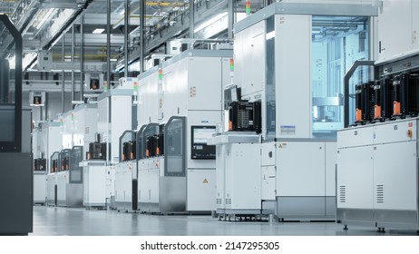 Wide shot of Bright Advanced Semiconductor Production Fab Cleanroom with Working Overhead Wafer Transfer System  - Shutterstock ID 2147295305