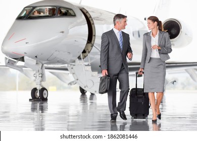 Wide shot of business employees discussing while walking away from the plane - Powered by Shutterstock