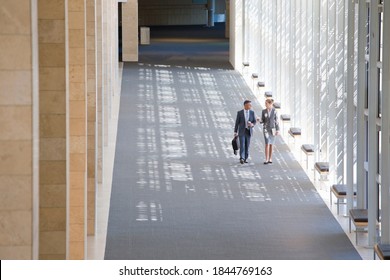 Wide Shot Of Business Employees Walking In The Lobby Of A Modern Office