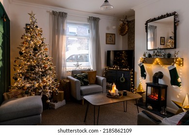 A Wide Shot Of A Christmas Tree Decorated With Golden-orange Shiny Balls And Lights In A Living Room.