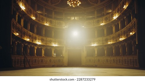 Wide shot of an Empty Elegant Classic Theatre with Spotlight Shot from the Stage. Well-lit Opera House with Beautiful Golden Decoration Ready to Recieve Audience for a Play or Ballet Show