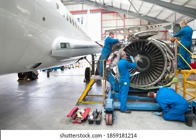 Wide shot of engineers assembling an engine of a passenger jet at a hangar. - Shutterstock ID 1859181214
