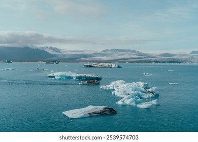 Wide shot of Icelandic glacial lagoon with scattered icebergs, reflecting the muted sky, likely Jökulsárlón in Iceland. - Powered by Shutterstock