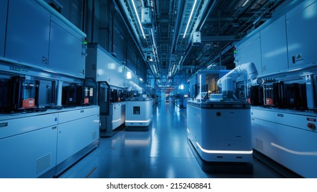 Wide Shot Inside Advanced Semiconductor Production Fab Cleanroom. Automated Robots Are Transporting Wafers Between Machines.