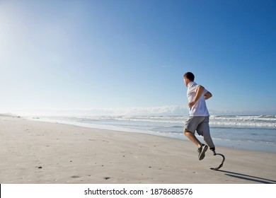 Wide shot of a Man With prosthetic Leg Running Along the Beach - Powered by Shutterstock