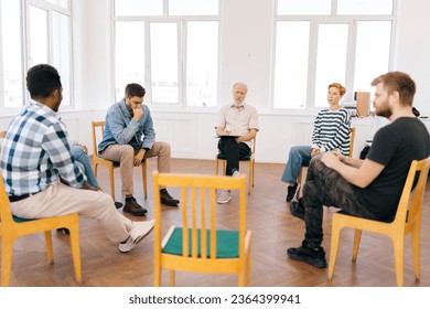 Wide shot portrait of senior male speaking on therapy meeting of addicts, sharing problem, giving support to teammates. Businessman, boss talking to colleagues, sharing ideas to project staff - Powered by Shutterstock