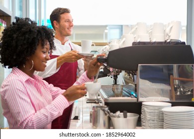 Wide Shot Of Smiling Waiters Preparing And Serving Coffee In A Coffee Shop