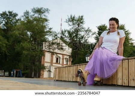Wide shot of smiling woman while roller skating in park 
