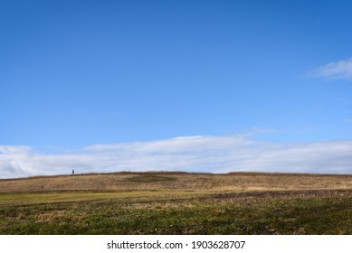 Wide Shot View Of A Man Walking Across A Field.