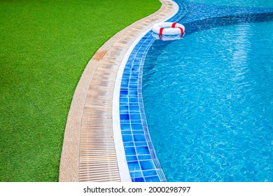 Wide swimming pool and green artificial turf inside the villa - Shutterstock ID 2000298797