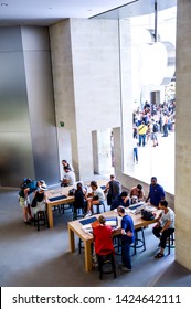 Wide View Of Apple Store Genius Bar With Sitting Clients Using MacBook . Paris , France . July 2015